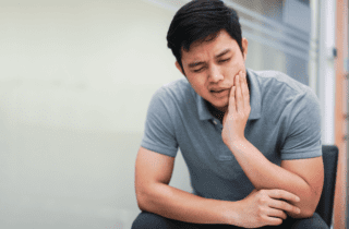 man holding his jaw in pain | dentistaltamonte.com